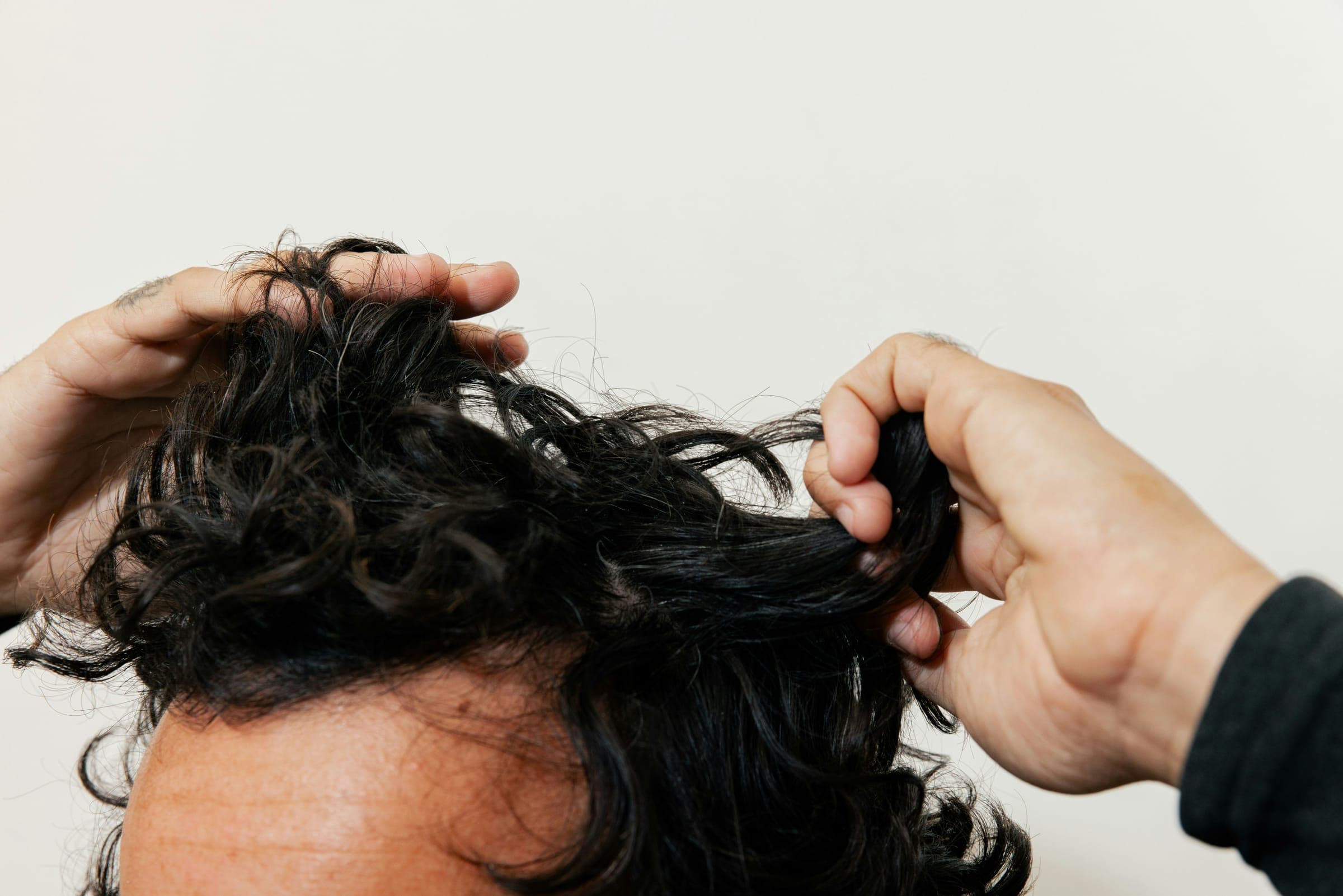 Man with hands in dark curly hair
