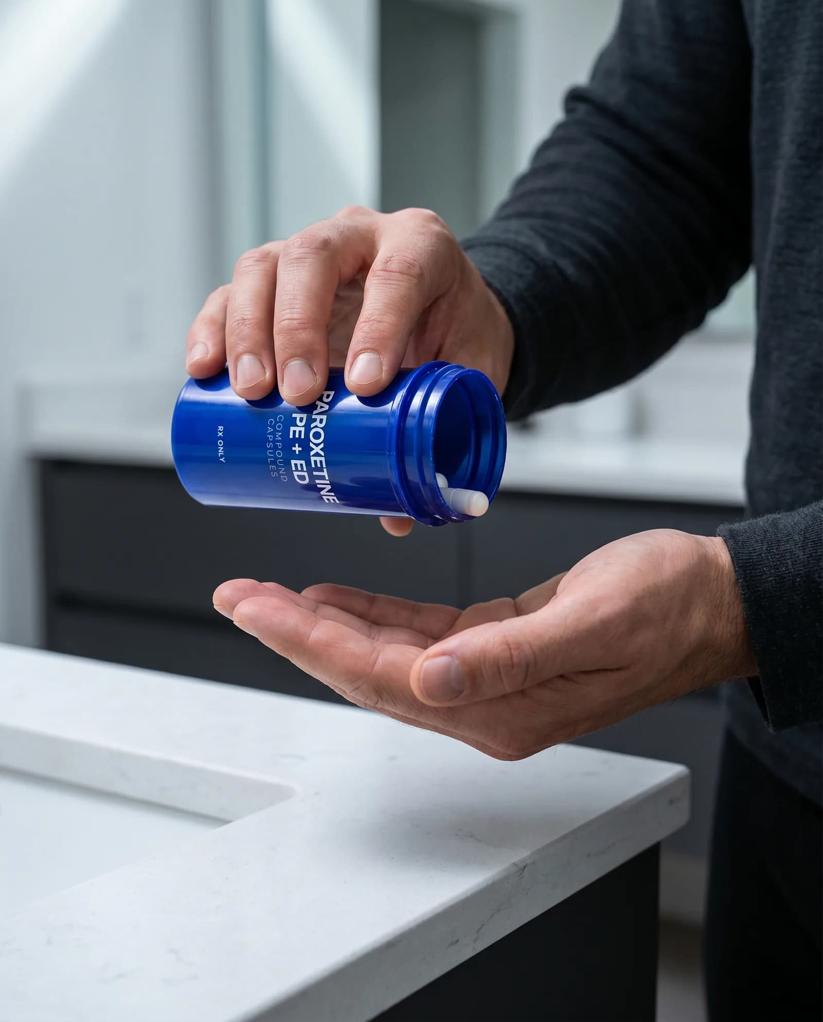 Man pouring ParoxetineRx PE + ED capsules from the bottle into his hand