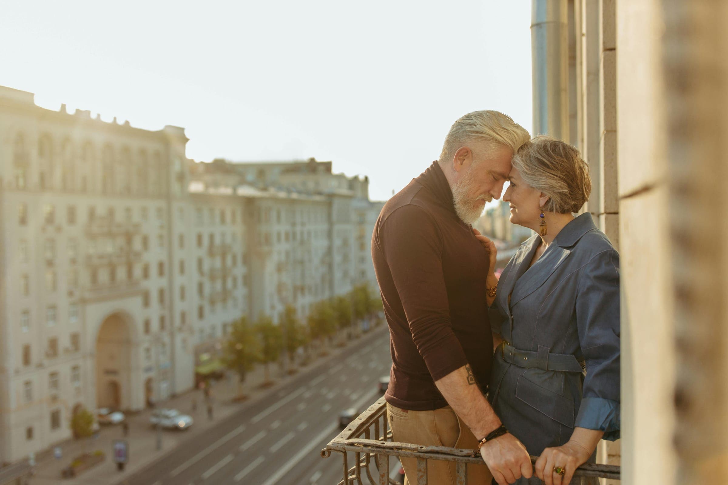 Couple embracing on a balcony at sunset