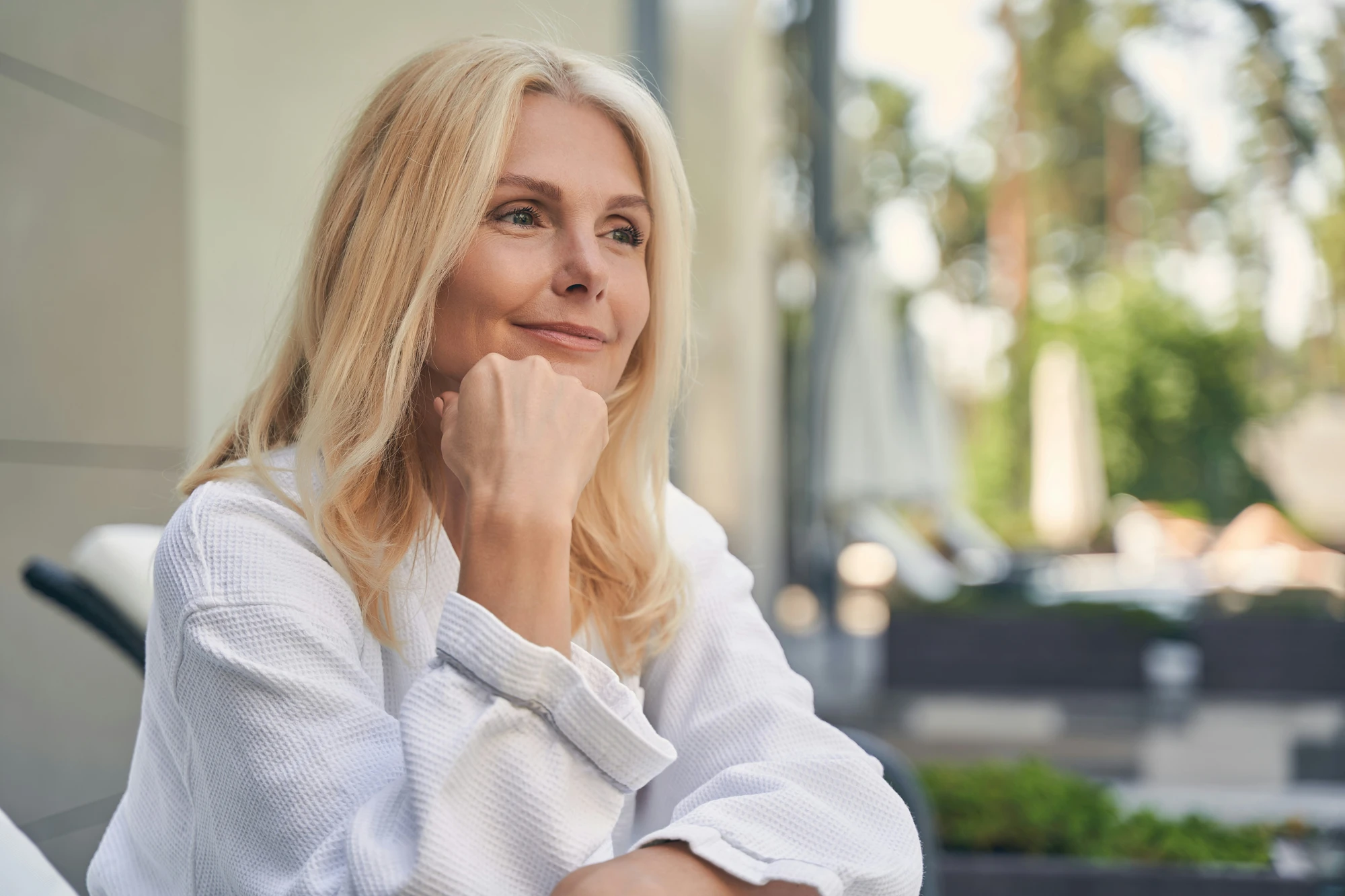 Woman smiling thoughtfully outdoors