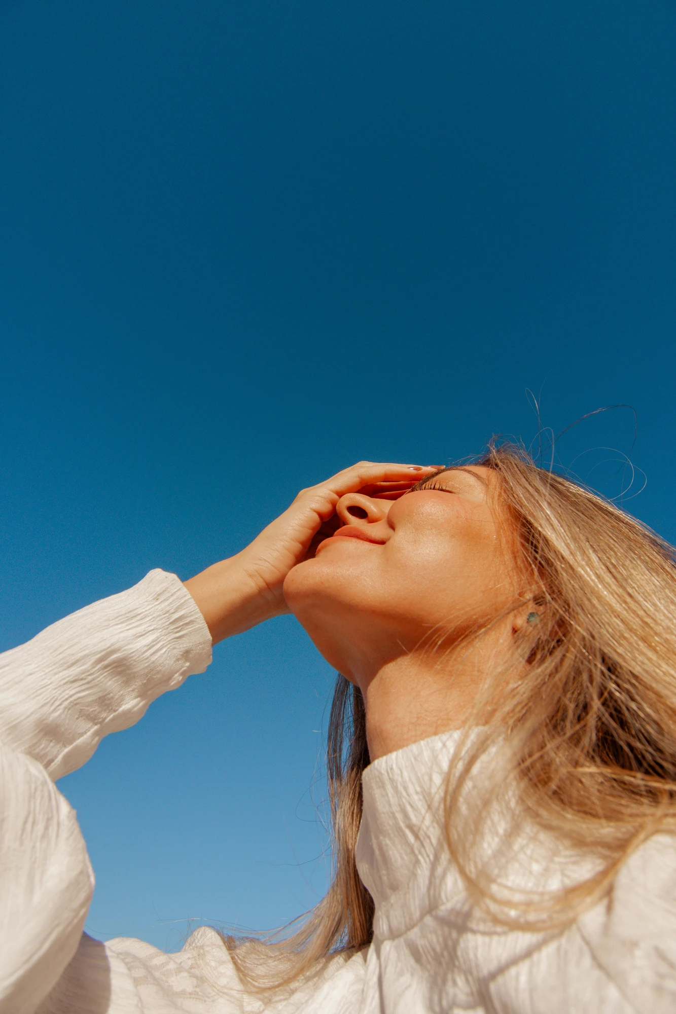 Woman with sunlit skin, eyes closed