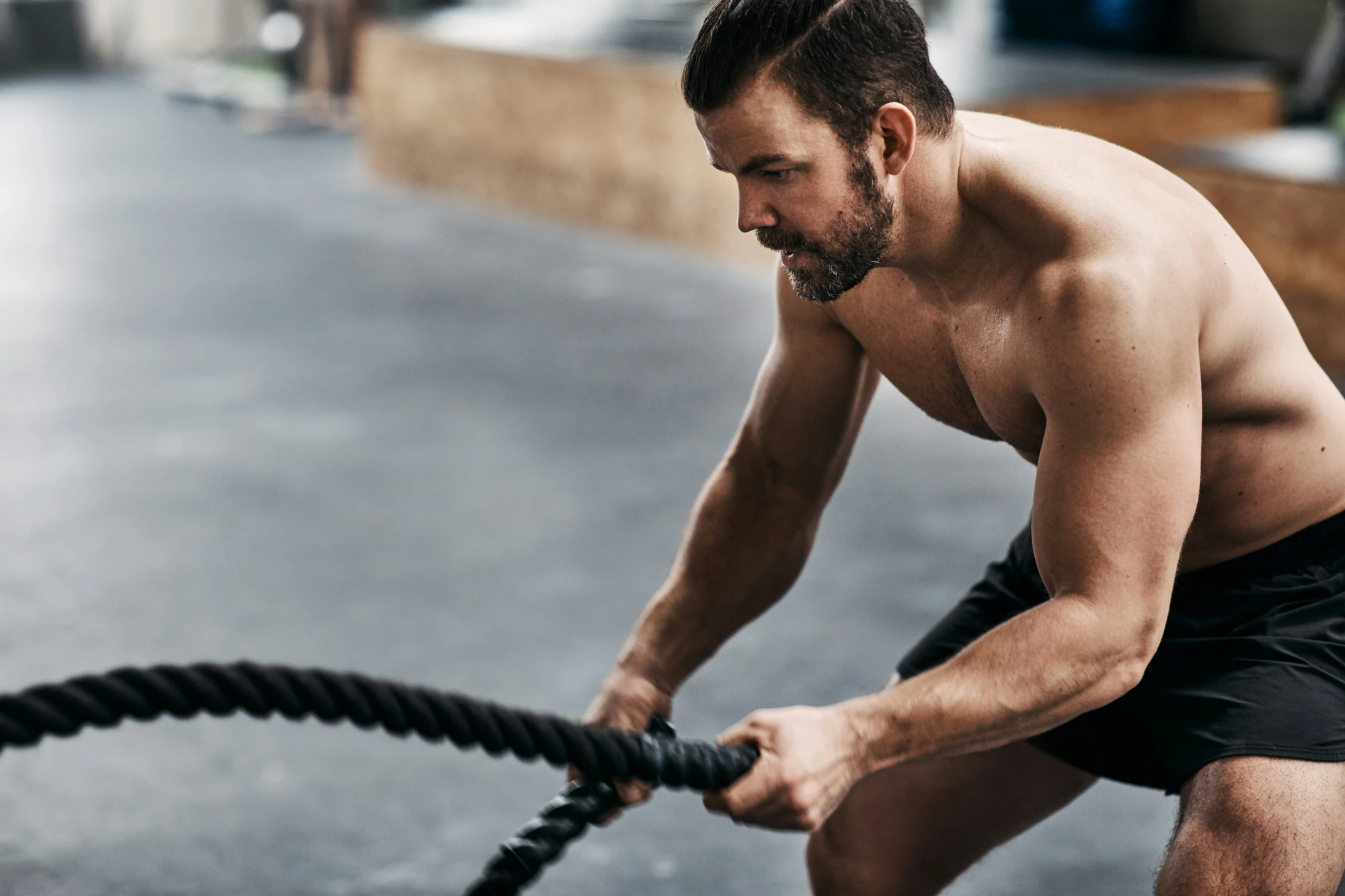 Man doing battle rope exercises at the gym