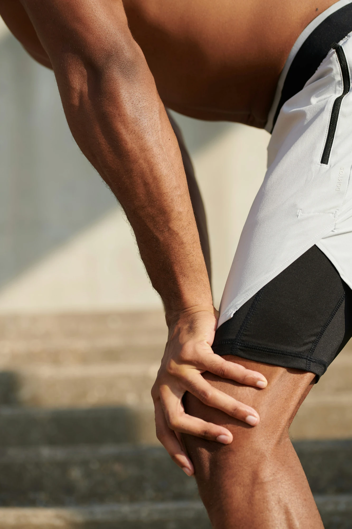 Close-up of a man stretching his leg outdoors